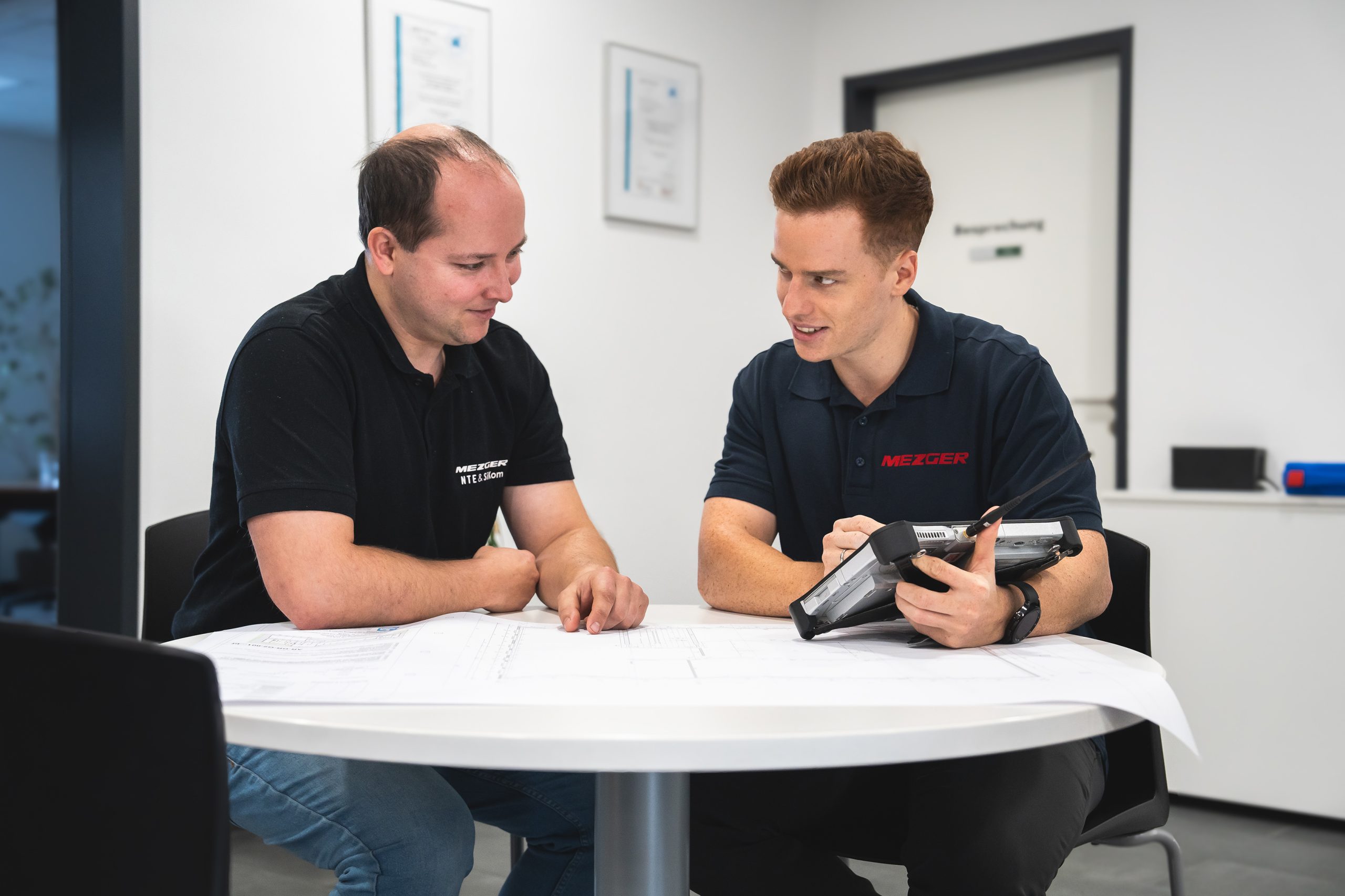 Mehrere Mitarbeiter sitzen am Tisch und planen ein Projekt