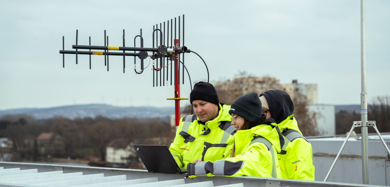 3 Mitarbeiter führen auf dem Dach eine Funkmessung durch